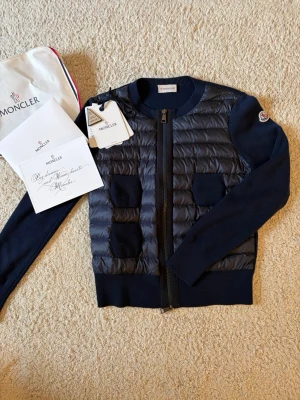 Mörkblå cardiganjacka från Moncler - Säljer min snygga mörkblå cardiganjacka från Moncler med quiltad front och fyra fickor. Storlek xxs. Köpt på Arkivet våren 2025 för 4000kr. Har knappt använts. Pris kan diskuteras vid snabb affär (Köparen står för frakten)💞