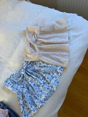 Två korta kjolar i blommigt och spets - Säljer två söta toppar, dom är knappt använda och är i så fint skick. Säljer dom tillsammans för 80kr. Storlek S  