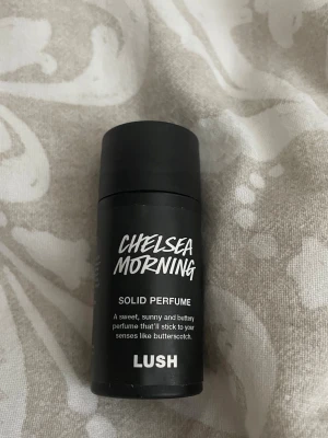 Chelsea Morning Solid Perfume Lush - Chelsea Morning solid parfym från Lush i en svart cylinderformad förpackning. Doften beskrivs som söt, solig och smörig med toner av kola. 