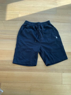 Marinblåa short från Ralph Lauren  - 👕 Märke: Polo Ralph Lauren 📏 Storlek: M 🎨 Färg: Marinblå med vit logga ✨ ☀️ Stilrena och bekväma shorts från Polo Ralph Lauren – perfekta för sommaren. Enkel och tidlös design som passar lika bra till t-shirt som hoodie. Tillverkade i mjukt och skönt material med ikonisk vit logga.  ✨ Skick: Helt nya med tags kvar 🧼 Aldrig använda 👌 Perfekta för både vardag och semester