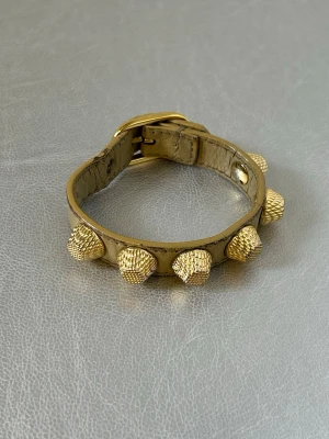 Guldfärgat armband från Balenciaga  - Denna vara kommer att auktioneras ut på Plick Live den 27 maj klockan 18:00