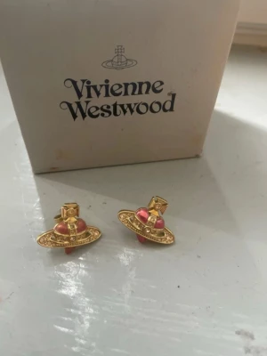 Vivienne westwood earrings örhängen - Guldiga jätte fina örhängen. Ena pluppen e borta men annars e de som gott som nya