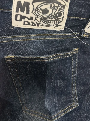 Mörkblå jeans från Monday - Snygga mörkblå jeans från Monday med raka ben och coolt tryckt logotypmärke bak. Jeansen har klassisk femficksdesign och kontrastsömmar. Materialet är denim med lätt slitning framtill för en trendig look.