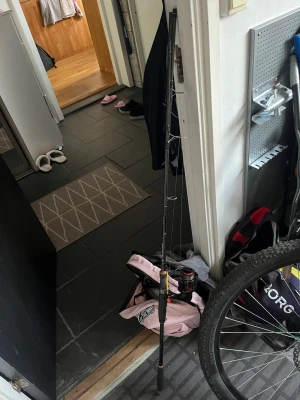 Svart och röd fiskespö med rulle - Fiskespö med tillhörande röd och svart Ceymar CX rulle. Spöet har flera öglor och är utrustat med fiskelina. Perfekt för dig som vill ut och fiska, både för nybörjare och erfarna. Materialet är robust och spöet har en sportig design.