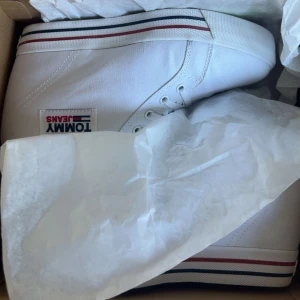 Isabel marant liknande - Nästan nya Tommy Jeans wedge sneakers- vita med hög platåsula, klassisk snörning och ränder i rött/blått. Använda 1 gång, i perfekt skick. Tyvärr för små för mig därför jag säljer💕 Nytt pris: 1200 kr, säljer för 649 kr (pris kan alltid diskuteras)💕skriv vid frågor!!!