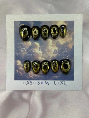 Noctra (M);ExtraShortAlmond  - Unika handgjorda press-on naglar i svart med skimrande cateye guld och handmålade motiv av månar, solar och stjärnor. Naglarna har en extra kort manddl form och är i storlek M: 16 mm, 12 mm, 12,5 mm, 11,5 mm, 10 mm. Perfekt för dig som vill ha en mystisk och kreativ look.