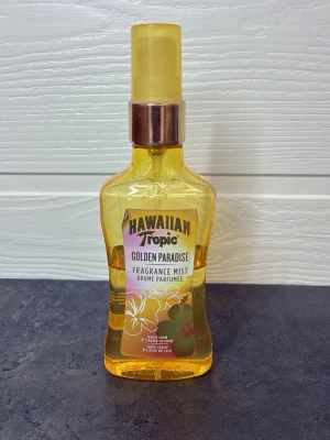 Hawaiian Tropic Golden Paradise mist - Doftmist från Hawaiian Tropic i doften Golden Paradise. Flaskan är genomskinlig med gul ton och har en gul spraykork med silverdetalj. Doften har inslag av varm sand och krämig kokos. Perfekt för dig som gillar tropiska och somriga dofter.