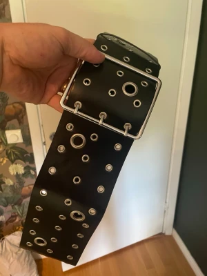 Brett svart bälte med nitar - Nytt konstläder bälte som är 110cm långt. Bredd: 95mm