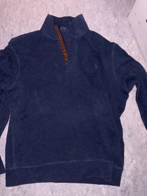 Mörkblå tröja från Polo Ralph Lauren - Mörkblå tröja från Polo Ralph Lauren, halv zip inte använt många gånger max 1-2 gånger storlek M 