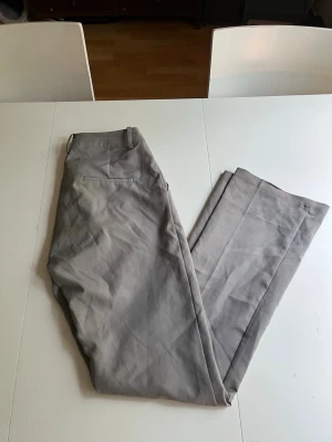 Hög midjade kostymbyxor - Ett par högmidjade kostymbyxor från Bik Bok i storlek 38/M. Fortfarande i jättebra skick förutom längst nere vid fötterna ( se bild 3,4 )💕