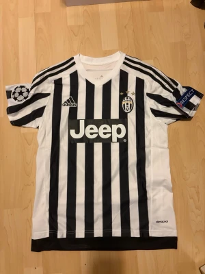 Juventus 15/16  hemmatröja Pogba #10  - Juventus 15/16  hemmatröja med Pogba #10 på ryggen inte använd alls (kan även passa storlek S) Skickas inom 24h📦…………………………………………………Juventus matchtröja i svartvitt med vertikala ränder, Adidas-logga och Jeep som sponsor på bröstet. Pogba och nummer 10 på ryggen. Champions League-märke på ena ärmen och Respect-märke på andra. 