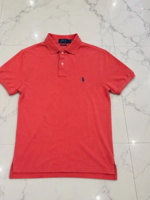 Ralph Lauren Piké - Säljer en rosa/corall Ralph Lauren Piké i storlek S. Den är slim fit och har inga defekter alls. Skulle säga att skicket är 9/10. Hör av er vid funderingar 