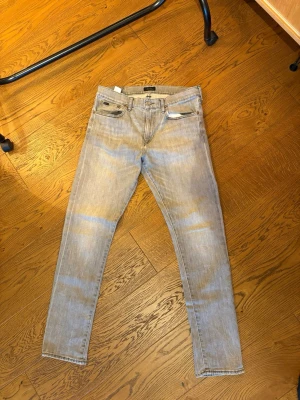 ralph lauren jeans 33x32 slim  - ralph lauren jeans med grå tvättning. Jeansen har midje öppning på 41cm Altså är jeansen mindre än storleken. Liten fläck ifrån färg på innerbenet. 