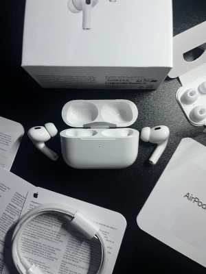 Apple Airpods Pro 2 - Komplett - Säljer ett par vita Apple AirPods Pro med laddningsetui. Hörlurarna har en stilren och kompakt design med silikonproppar för bra passform. Perfekta för musik, samtal och träning. Levereras med originalförpackning och extra öronproppar.
