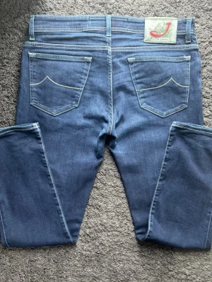Jacob Cohën 688 | Premium Denim - Lyxiga Jacob Cohën 688 i mörkblå tvätt. Perfekta för vardags & uppklätt, te.x till en blå  skjorta som matchar det mörkblåa. Handgjorda i Italien med högsta kvalitet och unika detaljer. 🧵 Märke & Modell: Jacob Cohën 688 Comfort 📏 Storlek & Passform: W33. Slim fit.  🧩 Material: 89% bomull, 8% poly, 3% elastan 📐 Mått: Midja: 43,5 cm Längd: 96 cm Benslut: 17,5 cm Lår: 27 cm ✅ Skick: 8/10. Fint skick, använda men med mycket liv kvar!💰 Nypris: Ca 4500 kr ‼️Skickas snabbt‼️