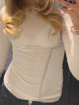 Intimissi tröja - Säljer en enkel och stilren vit långärmad topp med tight passform som bara är använd 2 gånger. Tillverkad i mjuk bomull som sitter skönt mot kroppen. Perfekt att styla med jeans eller kjol för en clean look. 