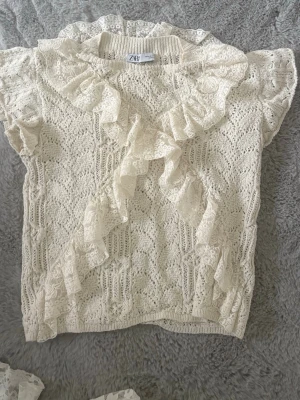 Vit spetsblus med volang från Zara - Superfin vit blus från Zara i spets, säljer då den aldrig kommer till användning. Använd ca 3 gånger🩷 storlek 38 men passar mer S/XS
