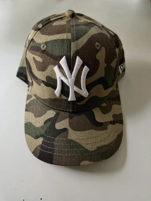 New Era - NY yankees keps - Säljer en camouflagemönstrad keps från New Era med justerbar passform. Perfekt för dig som gillar streetwear och sportig stil! 💕