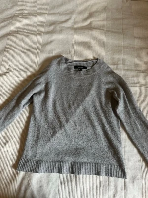 Grå stickad tröja från Vero Moda - Mysig grå stickad tröja från Vero Moda med rund halsringning och långa. Perfekt för lager-på-lager och enkel att matcha med jeans eller kjol.