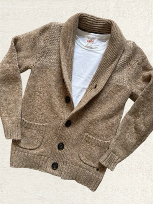 Stickad Cardigan - En mycket trevlig stickad kofta i en schysst beige färg! Storlek S, hör av dig vid frågor! 