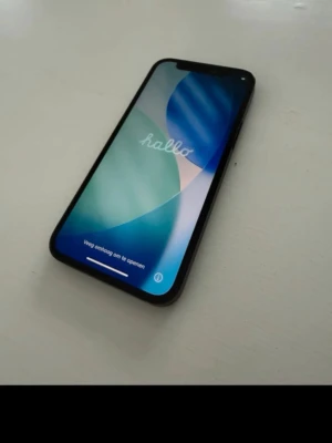 Svart iPhone 12 mini med slimmad design - Säljer en svart iPhone med modern, slimmad design och glas på framsidan. Telefonen har rundade hörn, stor skärm med minimala kanter och Face ID. Baksidan är mattsvart och ramen är i metall. Perfekt för dig som gillar stilren teknik och vill ha en kraftfull smartphone.