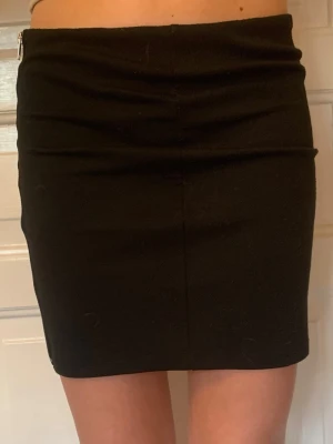 Svart kortkjol med dragkedja - Jag säljer en svart tight kjol från Kappahl (tror jag). Kjolen är ganska stor i storleken och passar därför mig som jag XS/S.