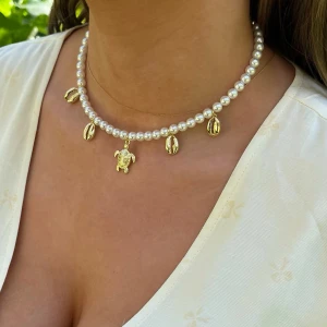 Pärlhalsband med charms - Pärlhalsband med Aurora Crystal Pärlor i färgen Cream. Charms i Guldpläterad mässing. 6mm stora pärlor. Längd 41cm inkl lås och förlängningskedja.  Jag skickar endast spårbart med post nord, samfraktar. Besök gärna mina övriga annonser.  Till mina smycken använder jag kristaller från Preciosa, Aurora och Swarowski.