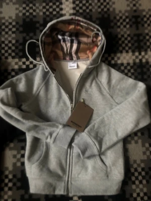 Grå zip hoodie från Burberry - Den är helt ny vill sälja den för att den var för liten på mig den är S men hade passat Xs