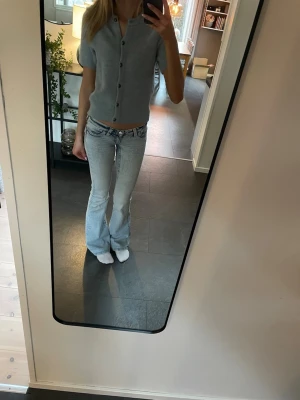 Ljusblå stickad kortärmad topp - Kortärmad ljusblå stickad topp med knappar framtill. 