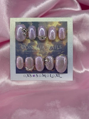 MoonLilac (S);ExtraShortOval  - Handgjorda press-on naglar i en skimrande lila/rosa nyans med silverglitter och kristaller. Naglarna har en oval form och är perfekta för dig som vill ha något extra. S: 15 mm, 11,5 mm, 12 mm, 11 mm, 9 mm, och designen är riktigt trendig.