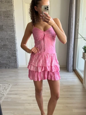 Rosa volangklänning med smala axelband - Säljer en söt rosa kortklänning med smala axelband och volanger. 💕