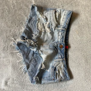 Ljusblå  jeansshorts - Riktigt snygga ljusblå jeansshorts med slitna detaljer och fransiga kanter. Perfekta för en avslappnad och trendig sommarlook.