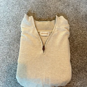 Beige half zip tröja Artu Napoli S - Beige långärmad tröja från Artu Napoli i storlek S. Tröjan har en stilren half zip-dragkedja vid kragen och ribbade muddar vid ärmslut och midja. Perfekt för lager-på-lager och chill stil. Materialet känns mjukt och lätt, troligen bomull eller bomullsblandning.