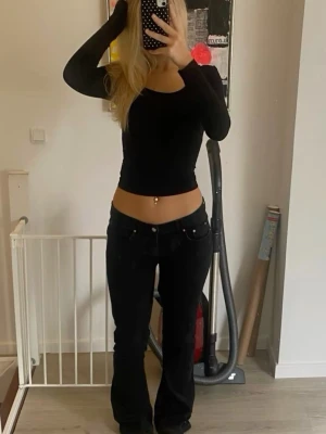 Svarta bootcut jeans från Nelly  - Säljer ett par svarta bootcut jeans från nelly med klassiska bakfickor och diskreta sömmar. Jeansen har låg midja och är tillverkade i ett stretchigt denimtyg som sitter snyggt på kroppen. Perfekta för en trendig och avslappnad look. Jag säljer eftersom de blivit försmå för mig💕de är köpta för 699