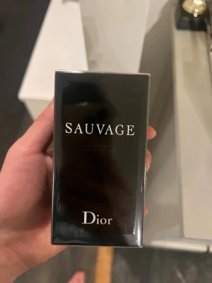Dior Sauvage Eau de Toilette - Säljer en Dior Sauvage Eau de Toilette. Parfymen kommer i en elegant, svart rektangulär kartong med vit text och Dior-logga på toppen. Perfekt för dig som vill ha en modern och fräsch doft med exklusiv känsla.
