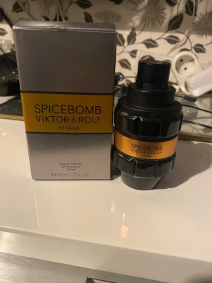 Spicebomb Extreme parfym 50ml - Spicebomb Extreme från Viktor & Rolf är en Eau de Parfum i en cool, granatinspirerad flaska med svart och orange detaljer. Flaskan rymmer 50 ml och har en robust, maskulin design med metallisk finish och tydlig logga. Perfekt för dig som gillar kryddiga dofter.Jag säljer en parfym som jag köpte på Montino. Den är bara använd tre gånger och är nästan ny.