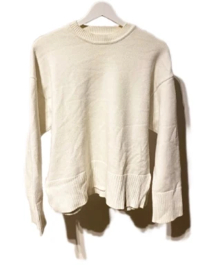 Vit stickad tröja från Zara - Säljer en vit stickad tröja från Zara i storlek S. Tröjan har rund hals, ribbade muddar vid ärmslut och nederkant samt en loose passform. Perfekt för lager-på-lager och chill stil. Materialet är mjukt och ger en skön känsla.