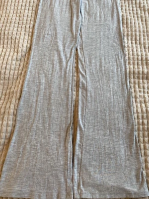 Grå yoga pants från Gina Tricot - Supersköna grå leggings från Gina Tricot med raka, vida ben och mjukt stretchigt material. Perfekta för chill dagar hemma eller när du vill ha en avslappnad look. Enkel design utan synliga fickor eller tryck. Säljer pga för små, pris kan diskuteras😇💞