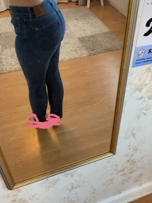 Mörkblå skinny jeans från Levi's - Säljer ett par mörkblå skinny jeans från Levi's med hög midja. Jeansen har en tajt passform hela vägen ner och de är stretchiga och sköna. Säljer åt min mamma då de ej passar henne längre 😕💗1000kr nypris, de är endast använda runt 3/4 gånger 
