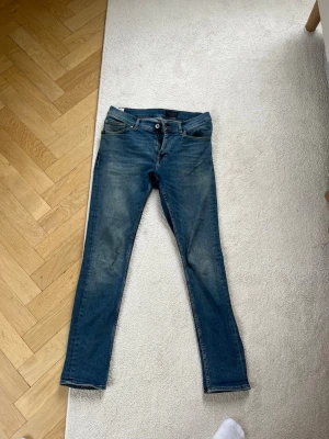 Jeans från Tiger of Sweden  - Säljer ett par blå slim fit jeans från tiger  Jeans med klassisk femficksmodell och dragkedjegylf. Jeansen har en snygg tvättad look  Perfekta för en avslappnad och trendig stil. Skicket är 8/10 och 29/30 i storlek. Nypris 1299 if 