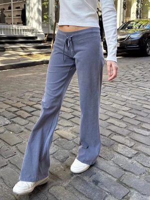 Yoga pants - Säljer ett par blå mjukisbyxor med bootcut-modell och dragsko i midjan. De är från Brandy Melville och modellen heter Hilary yoga pants. Byxorna har en avslappnad passform och är tillverkade i mjukt, stretchigt material som känns skönt mot huden. Perfekta för en chill och trendig look. Onesize men passar s/m