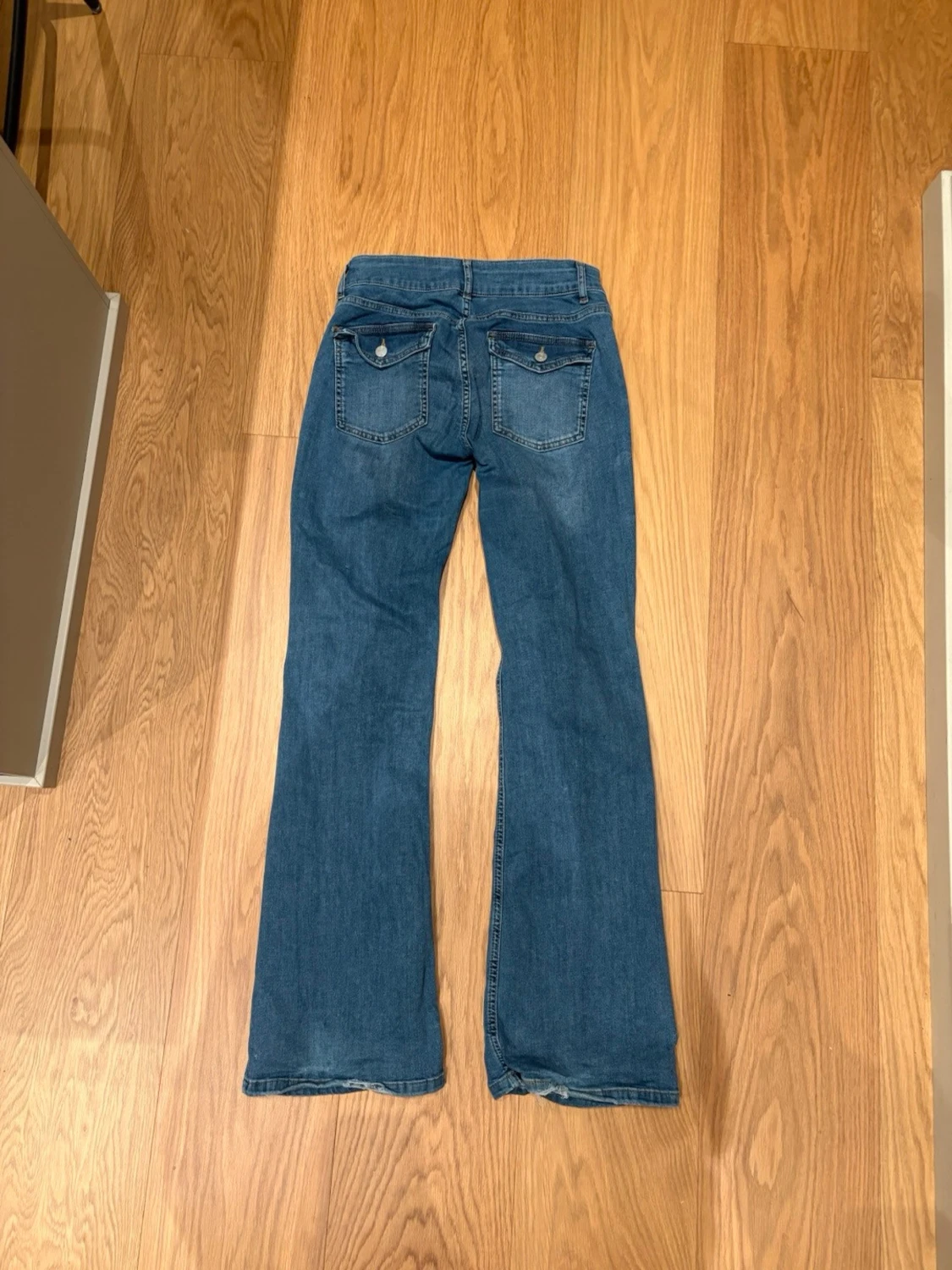 Blå bootcut jeans med knappar på fickorna - 1