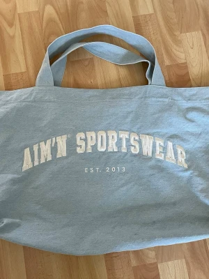 Aim’n varsity tote bag  - Varsamt använd, som ny Har en innerficka  Mått: Längd/djup: 12cm - Bredd: 65cm - Höjd 40cm  Perfekt nu till vår och sommar 🫶🏻🌸