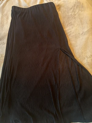 Långkjol - Säljer en svart långkjol från Gina som har en öppning i benet och är tunn med en underkjol och knappt använd typ 2-3 gånger ( priset kan diskuteras) 