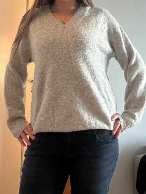 Ljusgrå stickad tröja - Mysig och varm ljusgrå stickad tröja från FB Sister med v-ringning. Köpt på new yorker. Storlek XS