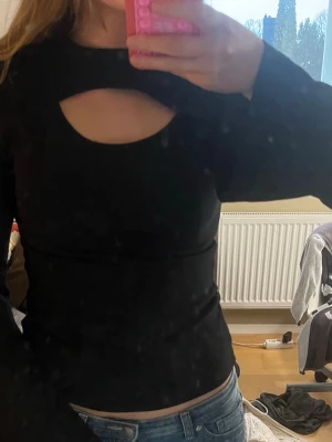 Svart långärmad topp med cut out - Svart långärmad topp med snygg cut out-detalj vid bröstet.❣️