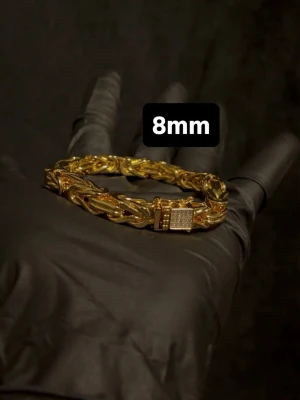 Kejsarlänk Armband 14K Guldplätering Diamantlås 8mm - Exklusiv kejsarlänk i 14K guldplätering! Utrustad med ett exklusivt diamant kistlås och stämpel 14K för en exklusiv känsla och look! Låset har hand-set VVS-D CZ stenar på! Storlek 8mm bredd och 21 eller 22cm i längd. Kontakta mig innan köp angående längd! Vikt ca 60g+ OBS: Armbandet är något stelt när det är stängt pga tjocka och tighta länkar, köp endast om ni är ok med detta.