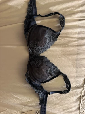 Svart spets-bh från intimissimi , 75B - Snygg svart bh från intimissimi med vadderade kupor och dekorativa spetsdetaljer över hela framsidan och axelbanden. Justerbara axelband och klassisk knäppning bak. Perfekt för dig som gillar en elegant och feminin stil.