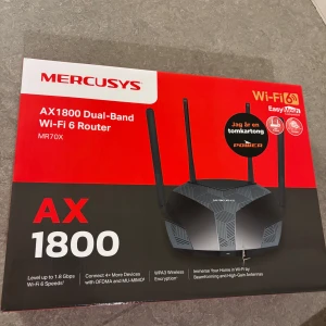 Mercusys AX1800 Wi-Fi 6 Router - Säljer en svart Mercusys AX1800 Dual-Band Wi-Fi 6 router, modell MR70X. Routern har fyra antenner, stöd för WPA3, MU-MIMO och OFDMA. Perfekt för snabba och stabila trådlösa nätverk hemma. Levereras med nätadapter och nätverkskabel.