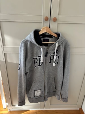 Grå hoodie från Storm  - Grå zip up hoodie från storm copenhagen tror inte den säljs mer! Mjuk och skön insida, dragkedja hela vägen och två fickor. Perfekt som vardagströja eller lager på lager!   Märkt XXL men upplevs mindre i storleken – skulle säga mer som XL eller stor L beroende på hur man vill att den sitter.  Bra begagnat skick, inga större slitningar eller fläckar vad jag kan se, dock nopprig!   ✨ Färg: grå ✨ Storlek: XXL (mindre i passformen) ✨ Modell: zip hoodie ✨ Skick: bra begagnat men är nopprig